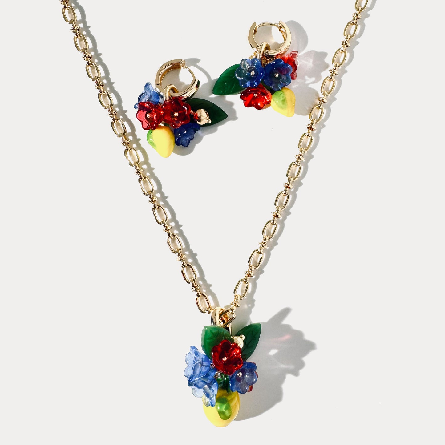 Handcrafted jewelry set with glass lemon and flower pendant necklace and matching 18K gold-plated earrings featuring glass lemons and flowers