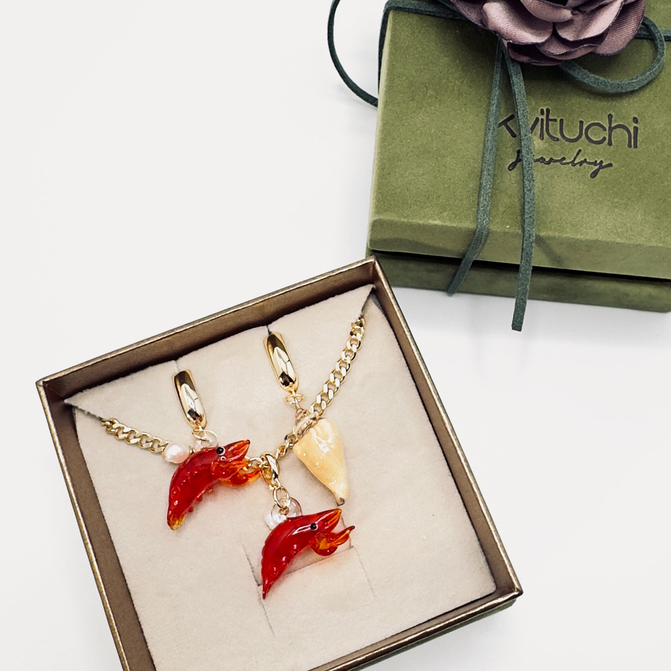 Glass lobster jewelry set with 18K gold-plated chain and asymmetrical earrings presented in a luxurious khaki suede gift box with gold accents
